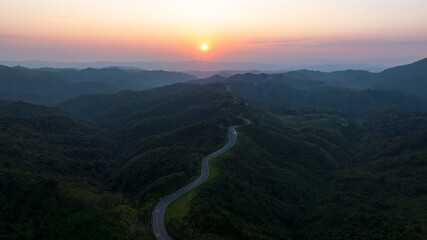 Wall Mural - andscape shadow of valley and thin mist caused by light of sunset in evening and Road No.1081 also hnow as Sky Road, winding along ridge between Pua Distric, Nan Province, is beautiful route north