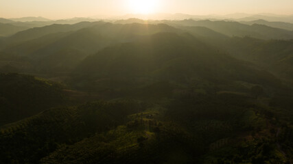 Wall Mural - Landscape of mountains layer and forests. The sun rays are shining through the fog. The play of light and shadows. dramatic natural scenery north of thailand. aerial view