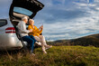 © Zoran Zeremski - Senior couple sitting against the car, resting after hiking in countryside.