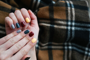 Wall Mural - Luxury short manicure on a dark wooden background. cozy autumn nails. 
