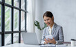 © crizzystudio - Portrait of young attractive woman working with laptop while sitting in the office, working finance concept.