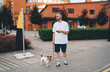 © BullRun - Casual male using phone while strolling with dog
