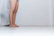 © thatinchan - A woman is examining her thighs and hips after trying diet pills because too much fat in her body makes her unhealthy. A young woman wears shorts to check the fat around her hips and thighs.