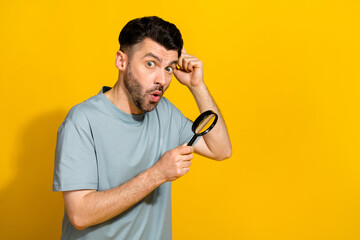 Poster - Photo of impressed man wear trendy outfit using magnifying glass impressed big size empty space isolated on yellow color background