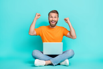 Sticker - Full size photo of ecstatic crazy funny man wear orange t-shirt white sneakers clench fists scream yeah isolated on teal color background