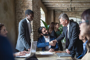 Wall Mural - Caucasian and hispanic businessmen colleagues shaking hands on meeting in office