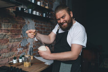 Joyful Bearded Chef Opening Jars With Ingredients During Dinner Preparation