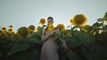 Model Standing Among Many Colored Sunflowers