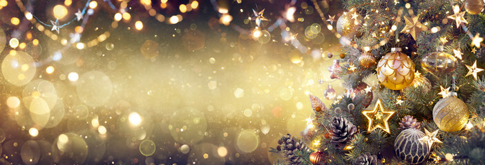 Wall Mural - golden christmas tree with baubles in shiny festive background - vintage ornaments on fir branches w