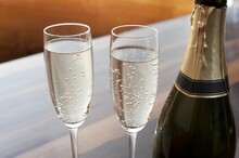 Closeup Of Two Elegant Flutes Of Sparkling Champagne Along Side A Champagne Bottle