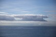 Scenic shot of a calm seascape with clouds lining horizontally on top