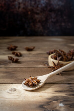 Anise Stars (Illicium Verum ) In Wooden Spoon And Wooden Bowl On Dark Rustic Wooden Background.