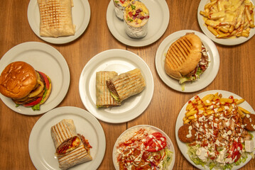Wall Mural - Set of fast food dishes with hamburgers, burritos and durum and kebab plates with falafel and sauces