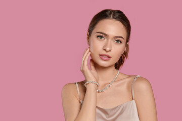 Poster - Young woman wearing elegant pearl jewelry on pink background, space for text