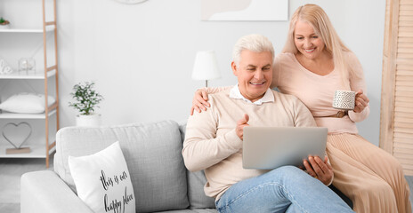 Sticker - Happy mature couple with laptop at home