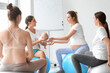 Female coach with baby and pregnant women training in gym