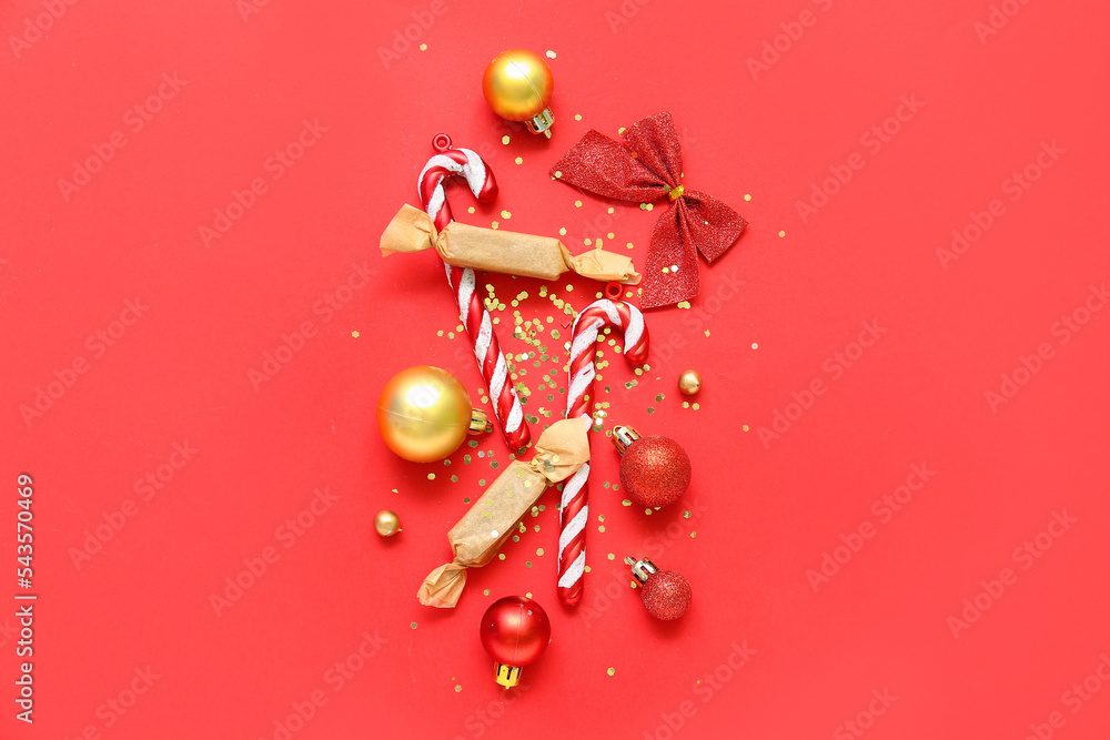 Beautiful Christmas composition with decorations, candies and confetti on red background