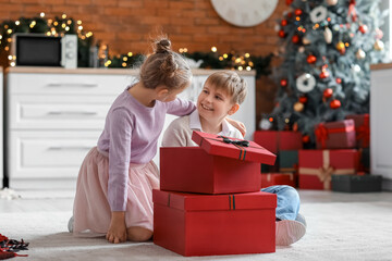 Sticker - Little children with Christmas presents sitting on floor in kitchen