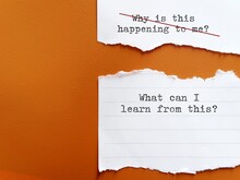 Torn Paper On Orange Background With Handwriting WHY THIS HAPPENING TO ME?, Changed To WHAT CAN I LEARN FROM THIS? To Overcome Negative Self Talk , Replace With Positive Thought To Boost Self Esteem