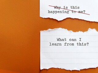 Torn paper on orange background with handwriting WHY THIS HAPPENING TO ME?, changed to WHAT CAN I LEARN FROM THIS? to overcome negative self talk , replace with positive thought to boost self esteem