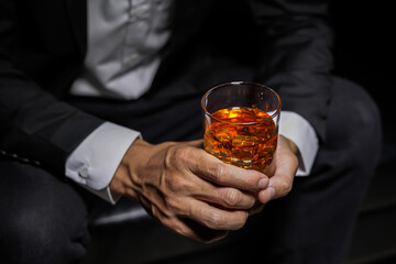 Closeup businessmen holding a glass of whiskey