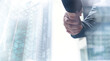 © tippapatt - Businessmen making handshake with modern buildings as background, business etiquette, congratulation, merger and acquisition, business meeting and partnership