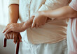 © J Maas/peopleimages.com - Support, disability and caregiver with senior patient helping him walk in retirement hands zoom and walking stick. Physical therapy, nurse medical professional help elderly or old man in nursing home