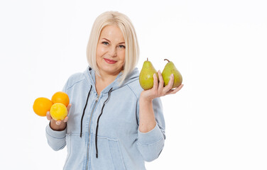 Happy woman with blond hair and beautiful smile holds two oranges, lemon and a pears in her hands for a healthy diet with vitaminswith. Concept healthy food fruits