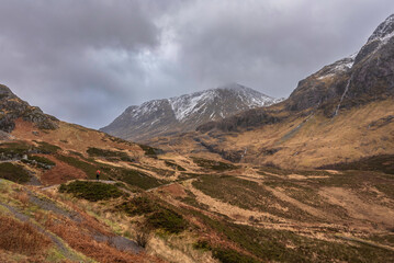 Wall Mural - Majestic Winter landscape image of snowcapped Three Sisters mountain range in Glencoe Scottish Highands with dramatic sky