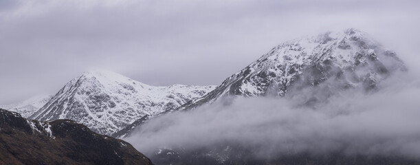 Wall Mural - Beautiful Winter landscape of Buachaille Etive Mor Stob Dearg in Scottish Highlands engulfed in low cloud with snowcapped peaks