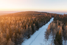 Sunset Over Orlické Hory (Eagle Mountines) From Poland Side In Jagodna. Forest And Road Covered In Snow.