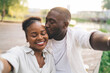 Happy black couple taking selfie with closed eyes