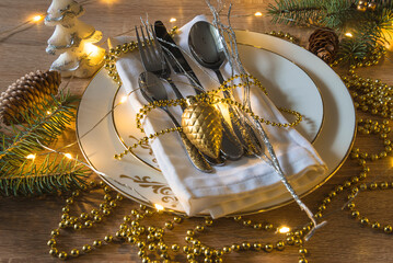 Canvas Print - Festive place setting for christmas holiday dinner in golden color and christmas lights