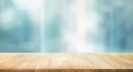 Wall Mural - Selective focus.Top of wood  table with window glass and cityscape background.