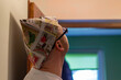 Mężczyzna patrzący w górę przygotowuje się do malowania pomieszczenia. Czapka z gazety chroniąca głowę przed farbą.