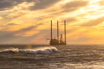 A jack up barge doing geotechnical survey work off the coast of long island in preparation for wind farm - Long Beach New York