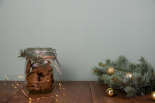 Christmas Concept - Glass Pot With Ginger Cookies, Christmas Fur Tree On Green Background.