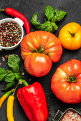 Canvas Print - Ingredients for cooking. vegetable with spices, bell pepper, chilli, basil, tomatoes and basil on a dark background. vertical image. top view