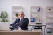 © Elnur - Old male employee sitting at workplace