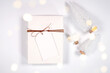 © millefloreimages - Christmas gift tag party favor thank you card mockup, styled with white reindeer and mini trees, bokeh party fairy lights on a minimalist white background.
