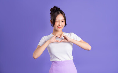 Wall Mural - Portrait of a beautiful Asian woman posing on a purple background