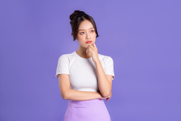 Wall Mural - Portrait of a beautiful Asian woman posing on a purple background