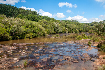 View of a beautiful river with a forest next to it and blue sky with clouds in the background