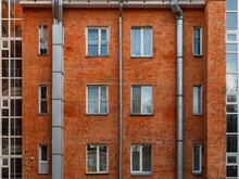 The Red Brick Facade Of Avant-garde Minimalist House With Pipe. Detailed Symmetric Picture Of Exterior Urban Architecture. Element Of Constructivism. Kuzbassugol Combine House, Novosibirsk, Gordeev.