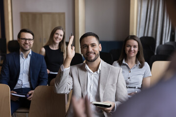 Sticker - Businessman take part in educational, motivational training event seated with colleagues attend together in seminar, raises his arm for ask question, participate in voting, having opinion to share it