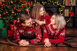 © ZaStock - Loving family mom dad and daughter having fun near Christmas tree over decorated living room