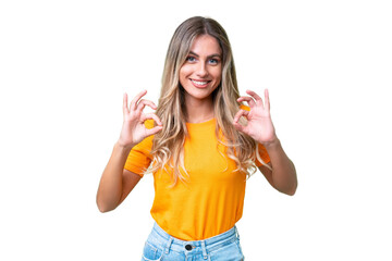 Wall Mural - Young Uruguayan woman over isolated background showing ok sign with two hands