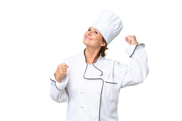 Wall Mural - Middle-aged chef woman over isolated background celebrating a victory