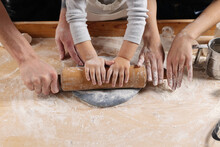 Family Hands Make Dough For Pizza Or Dumplings. Mom, Dad And Daughter Cook Together. The Team In The Kitchen.