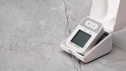 Wall Mural - Tonometer, automatic digital blood pressure monitor on the wrist, lying on the table, pressure diagnostics, on a gray background, place for text, banner